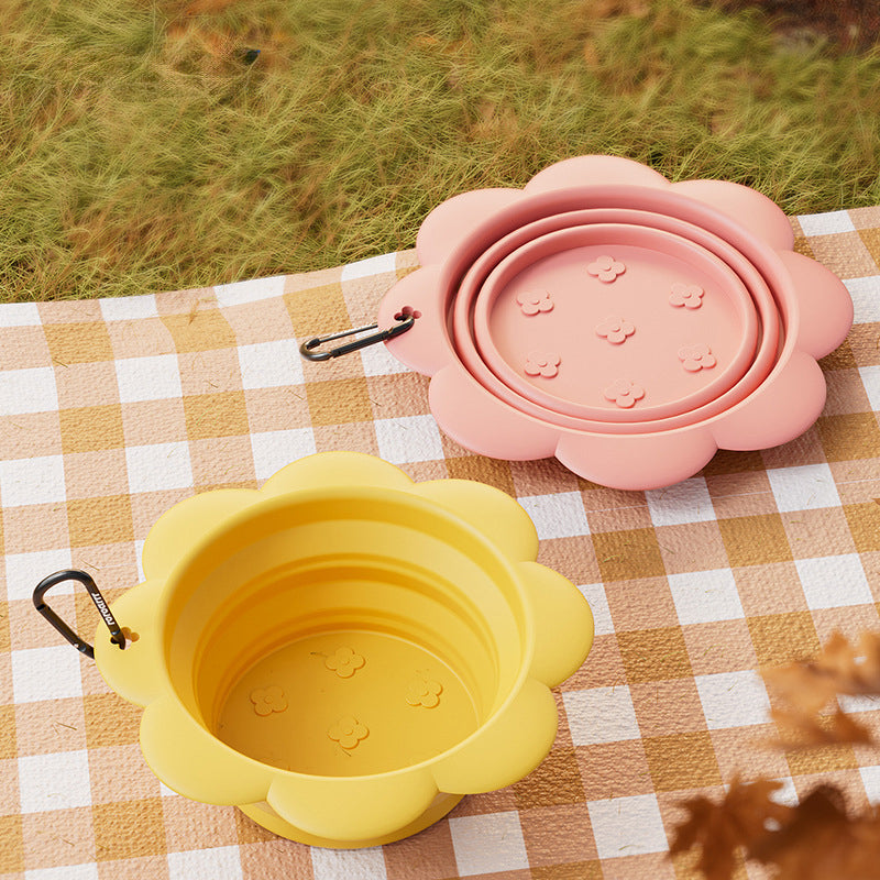 Yellow and pink travel bowls on a picnic blanket