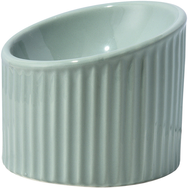 Cat eating from an elevated ceramic bowl